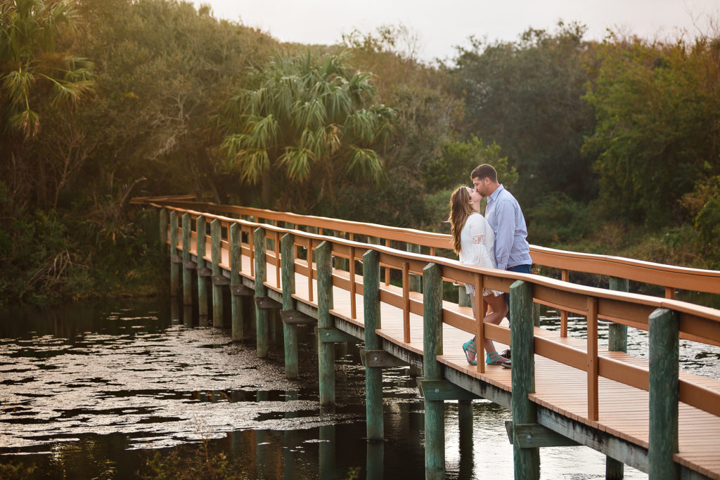 couple on bridge over water engagement photos